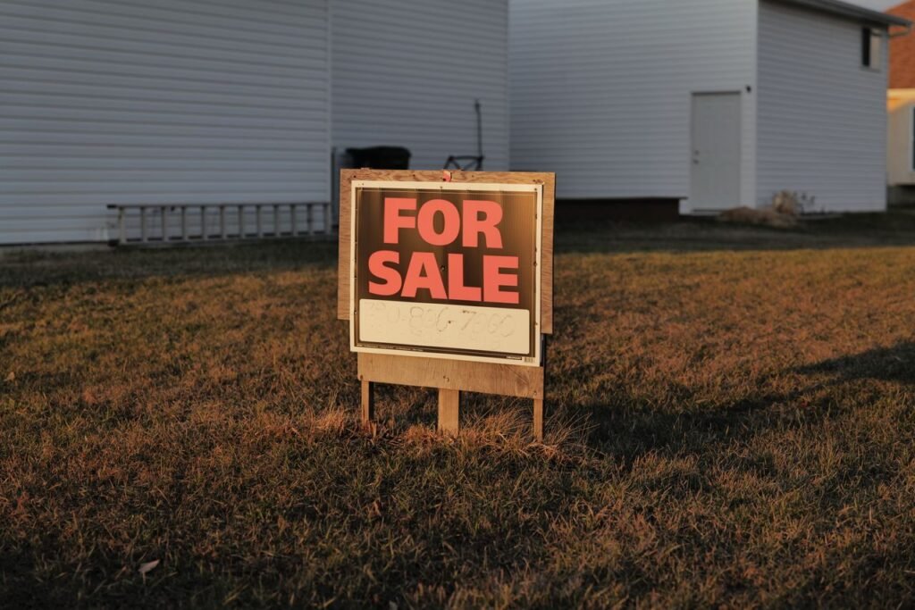 Why a Foreclosure Spike Isn't Likely: Clearing Up Misconceptions Close-up of a 'For Sale' sign in a suburban yard, indicating a property for sale.