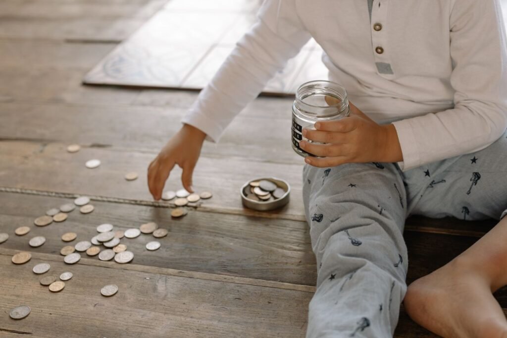 How Blake Saved a Fortune Without Giving Up Tacos or Vacations A young child collects coins into a jar on a wooden floor, symbolizing savings.